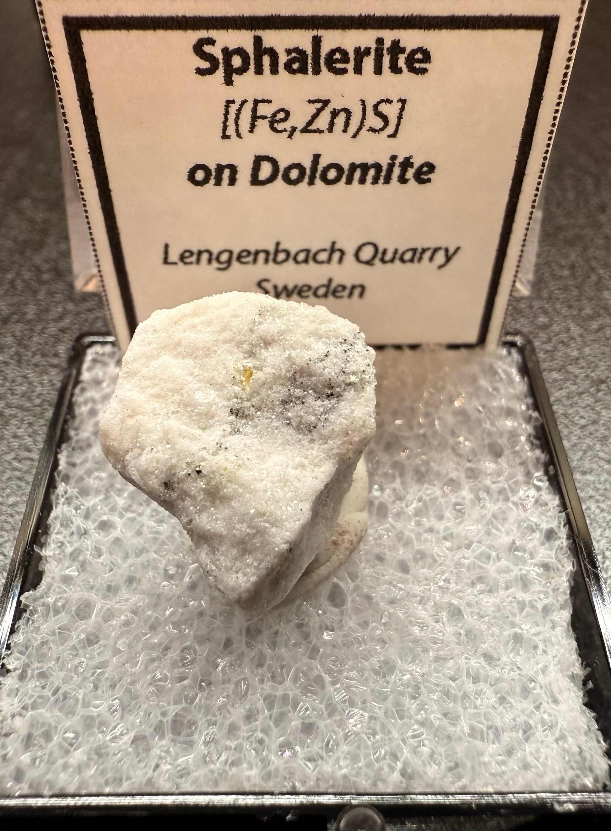 Mineral sample of sphalerite on dolomite with a label indicating origin